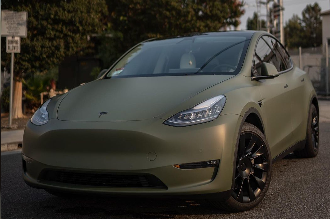 Front of a Tesla Model Y with military green vinyl wrap and ceramic coating
