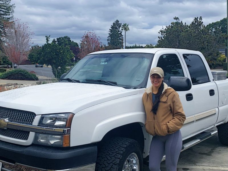 woman standing next to white truck